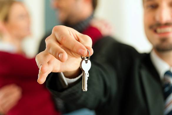 Photo of a real estate agent handing the keys of an apartment rental